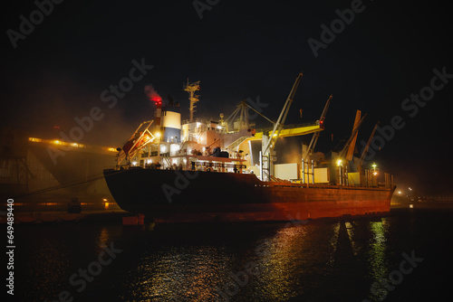 Night loading of grain into a cargo ship.