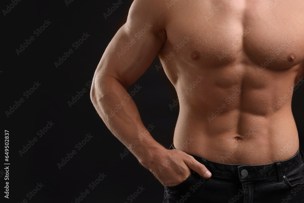 Muscular man showing abs on black background, closeup and space for text. Sexy body Muscular man showing abs on black background, closeup and space for text. Sexy body
