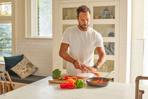 Man cutting vegetables in kitchen photo