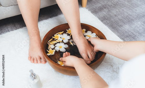 Fotografie Woman indulges in blissful foot massage at luxurious spa salon while masseur give reflexology therapy in gentle day light ambiance resort or hotel foot spa