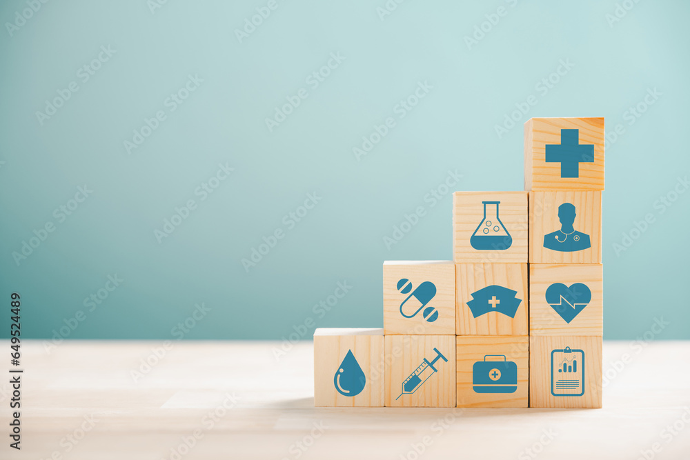 Obraz premium Wooden cubes in pyramid shape, illustrating the healthcare and insurance concept. Icon of medical insurance atop signifies protection. Blue background with copyspace for Health Insurance theme.