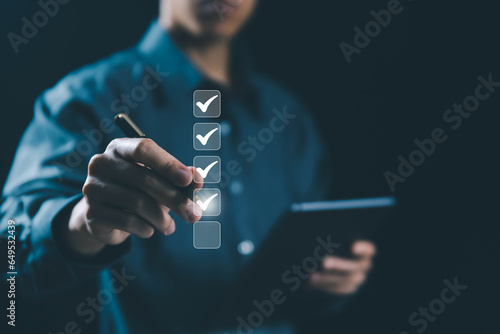 the person holding a tablet ticks the checkmark in the box. on the list of documents. the concept of check form online, checklist process order. business verify task detail and evaluation tick mark