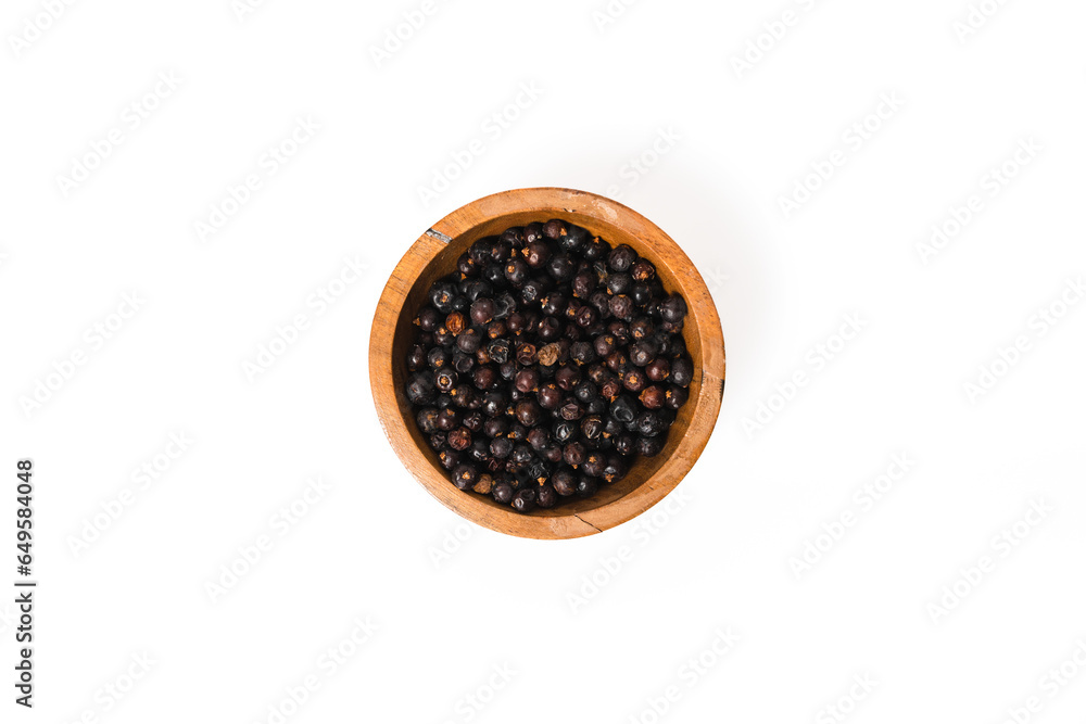 Purple juniper berries in a wood bowl on a white background Purple juniper berries in a wood bowl on a white background