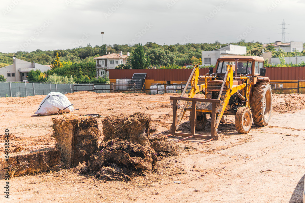 Obraz premium man moving straw with an old tractor