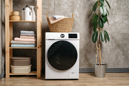 Laundry room interior with washing machine near gray grunge wall © fotofabrika