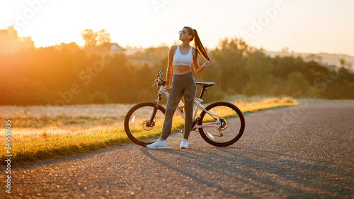 Brunette fit woman in sportswear with bicycle