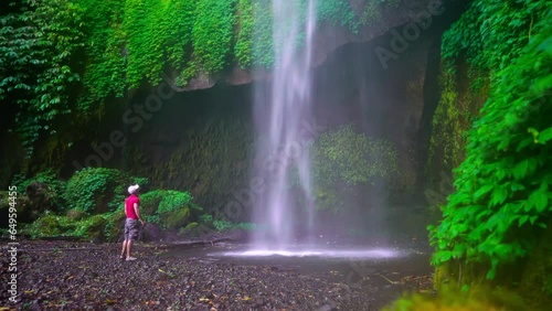 Active lifestyle travel people enjoy beautiful Bali waterfall Pucak Manik in tropical rainforest jungle on nature background Bali Indonesia 4K photo