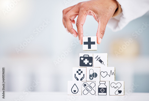 Hands, healthcare and a building blocks tower in a hospital with a doctor closeup for health insurance. Medicine, icon and symbol with a medicine professional in a clinic for cardiology or treatment