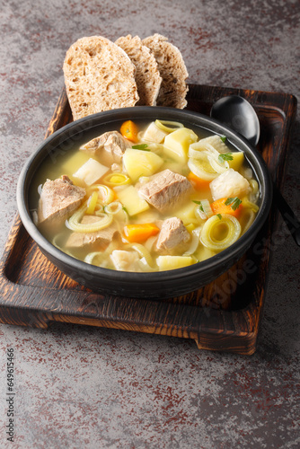 Finnish and Swedish Kottsoppa soup with beef, potatoes, carrots, leeks, celery and parsnip close-up in a plate on the table. Vertical photo