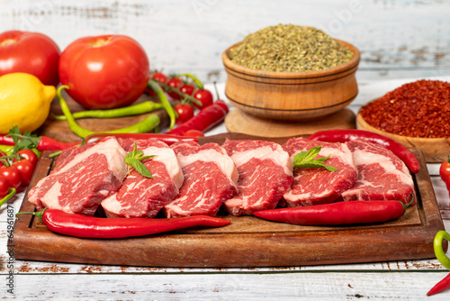 Veal entrecote meat on wood background. Raw beef rib eye steak with herbs and spices. Close up
