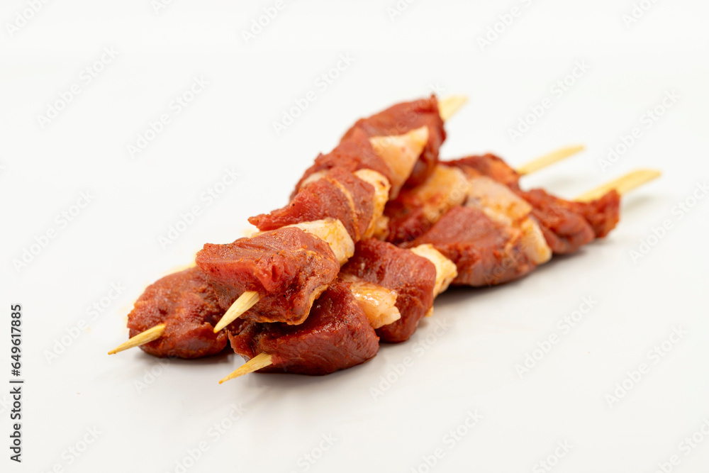 Beef tenderloin skewer isolated on white background. Beef tenderloin skewer with raw sauce with herbs and spices. Close up Beef tenderloin skewer isolated on white background. Beef tenderloin skewer with raw sauce with herbs and spices. Close up