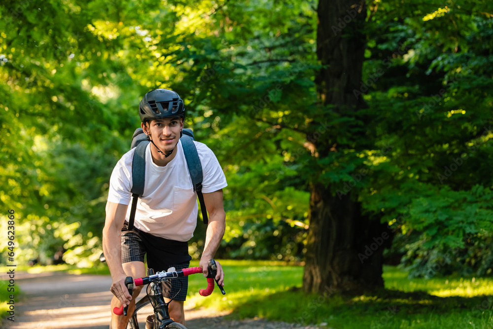 Obraz premium Cyclist on a bike on the road in the park