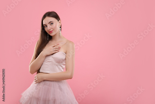 Beautiful woman in pale pink clothes on color background, space for text