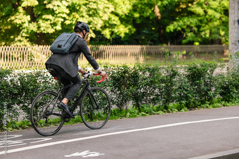 Naklejka premium Young manager commuting to work on electric scooter
