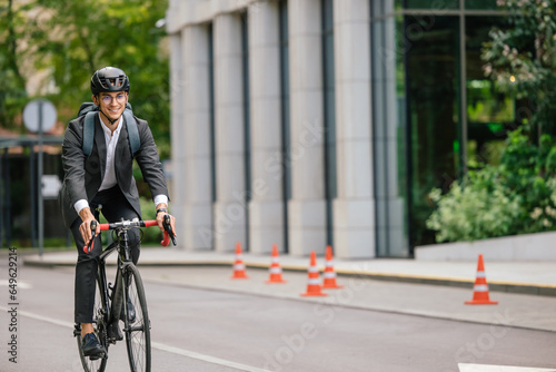 Young man in black suit riding a bike