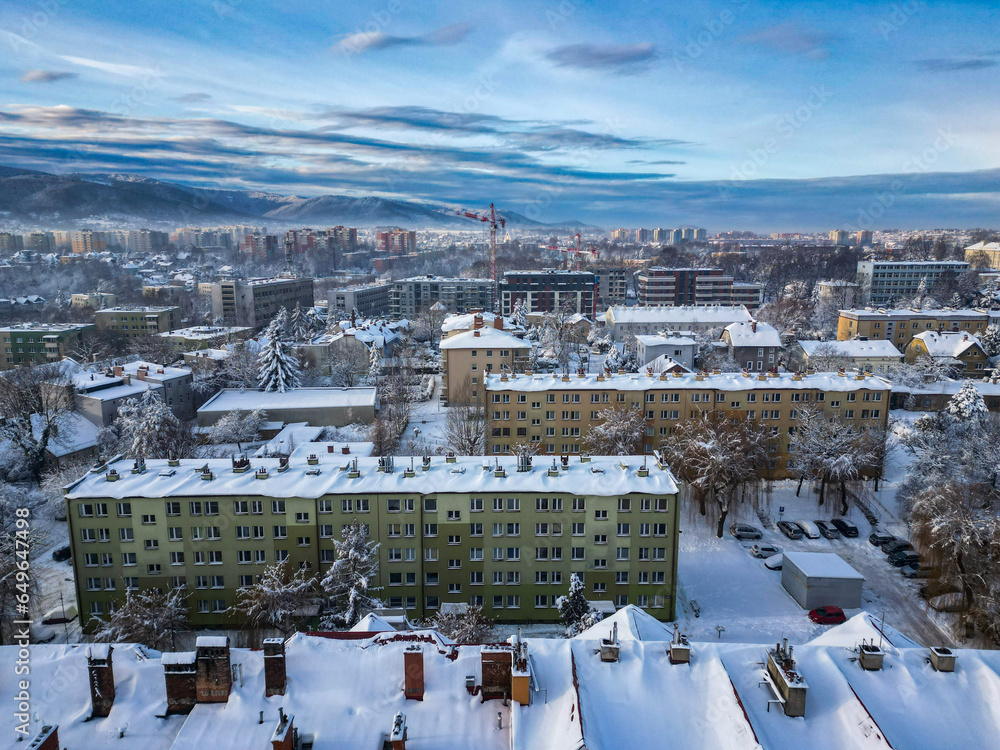 Obraz na płótnie Budynki i bloki mieszkalne miasta Bielsko-Biała w zimie widoczne z lotu ptaka, w tle góry Beskidu i lekko zachmurzone niebo  w salonie