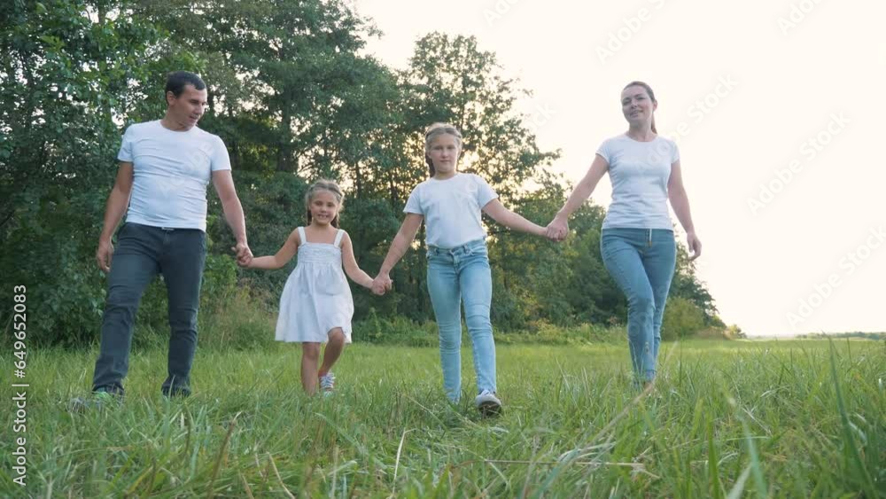 Happy family in park at sunset. mother, father,children girls walk in park at sunset together outdoors on green nature. concept of happy family in nature, parenting, adoption of children, walk in park Happy family in park at sunset. mother, father,children girls walk in park at sunset together outdoors on green nature. concept of happy family in nature, parenting, adoption of children, walk in park