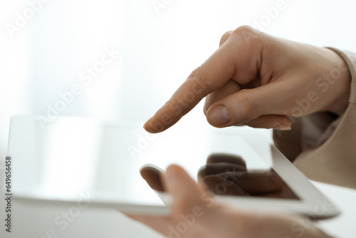 Closeup view of woman using modern tablet on blurred background