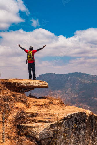 A hiker on a scenic view point at the top of mountain in Mbooni, Makueni County, Kenya