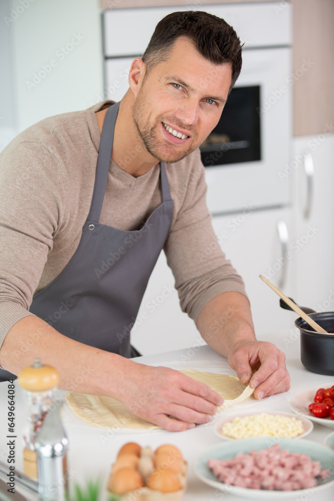 happy handsome man cooking in kitchen at home happy handsome man cooking in kitchen at home