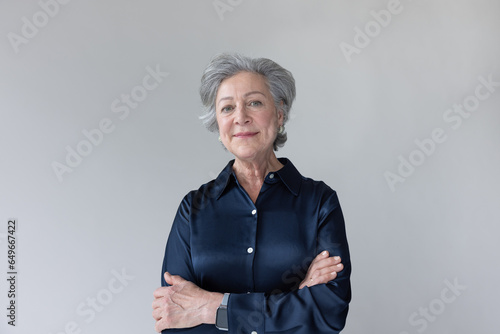Senior woman with grey hair looking to camera confidently