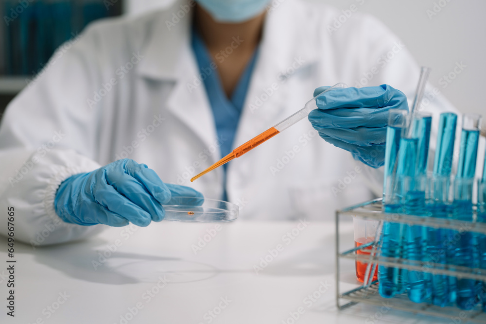 Fototapeta premium Science and medicine, scientist analyzing and dropping a sample into a glassware, experiments containing chemical liquid in laboratory on glassware, innovative and technology.