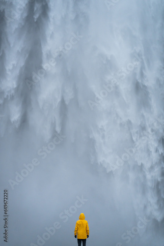 Mężczyzna stoi na tle wodospadu Skogafoss, Islandia © Witold
