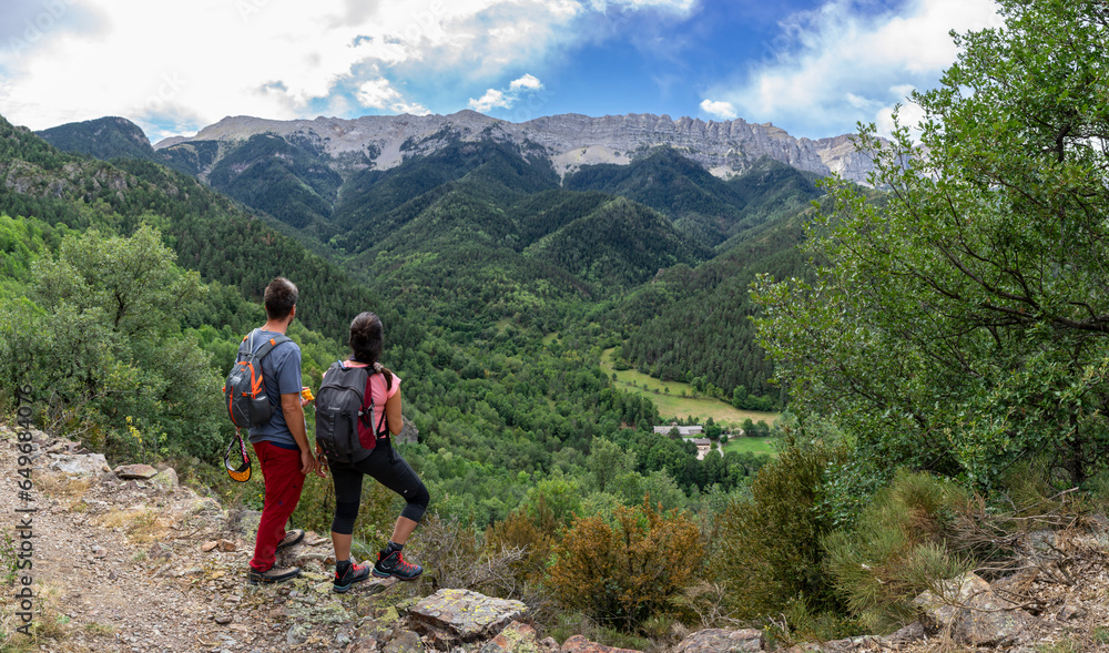 hikers observing the mountains and The Shrine of Saint Mary of Bastanist, Cadí-Moixeró Natural Park, Catalonia, Spain