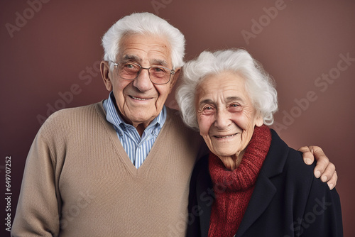 mid-shot of a 100 year old couple smiling, brown background, authentic, happy together photo