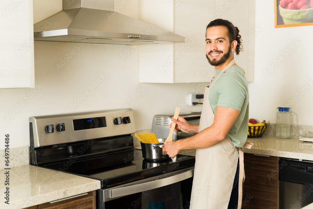 Cheerful man cooking or baking in the electric stove