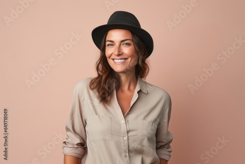 portrait of a confident Israeli woman in her 40s wearing a cool cap or hat against a pastel or soft colors background