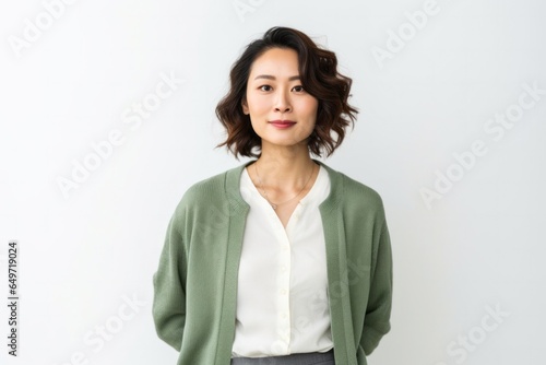 Portrait of a happy Japanese woman in her 30s wearing a chic cardigan against a white background