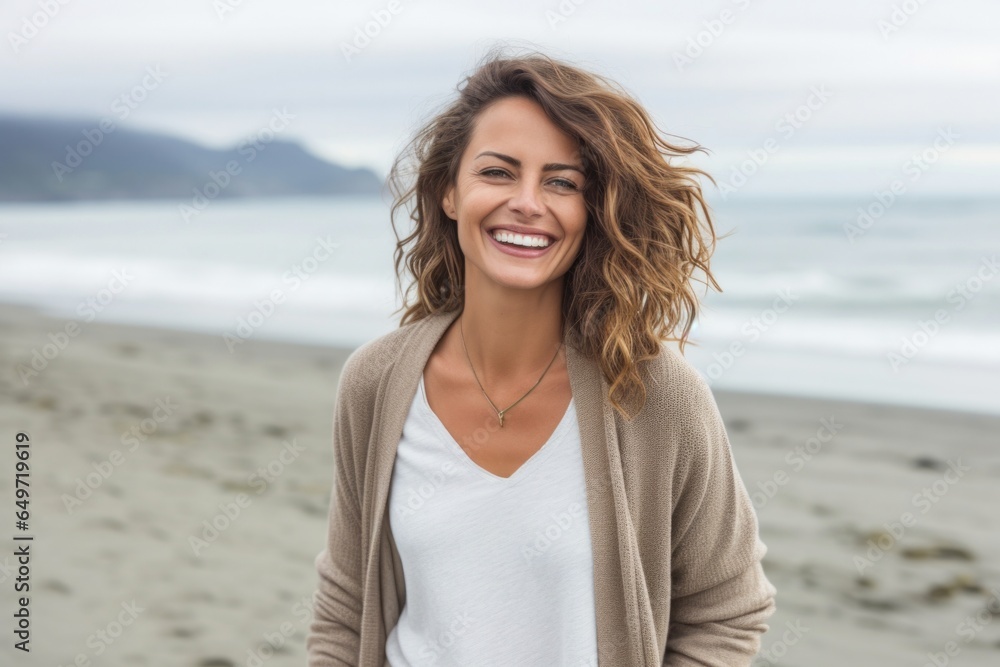 Portrait of a happy Polish woman in her 30s wearing a chic cardigan against a beach background Portrait of a happy Polish woman in her 30s wearing a chic cardigan against a beach background