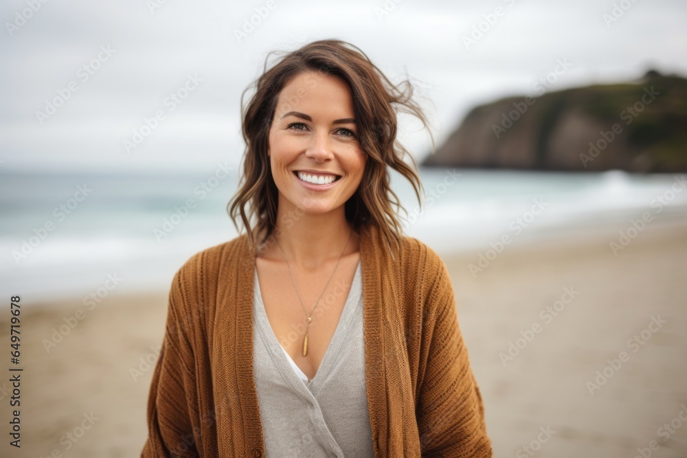 Portrait of a happy Polish woman in her 30s wearing a chic cardigan against a beach background Portrait of a happy Polish woman in her 30s wearing a chic cardigan against a beach background
