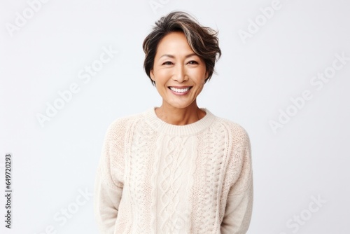 Portrait of a Filipino woman in her 40s wearing a cozy sweater against a white background