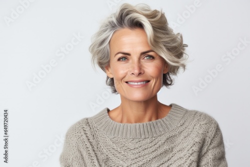 portrait of a confident Polish woman in her 40s wearing a cozy sweater against a white background