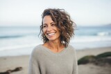 Portrait of a Israeli woman in her 40s wearing a cozy sweater against a beach background