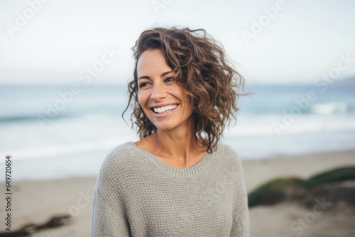 Portrait of a Israeli woman in her 40s wearing a cozy sweater against a beach background photo