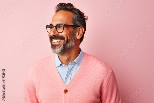 Portrait of a Mexican man in his 40s wearing a chic cardigan against a pastel or soft colors background © Anne-Marie Albrecht