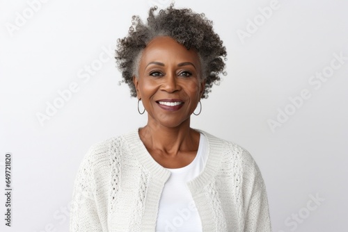 medium shot portrait of a confident Kenyan woman in her 50s wearing a chic cardigan against a white background