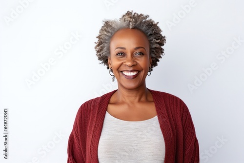 medium shot portrait of a confident Kenyan woman in her 50s wearing a chic cardigan against a white background © Leon Waltz