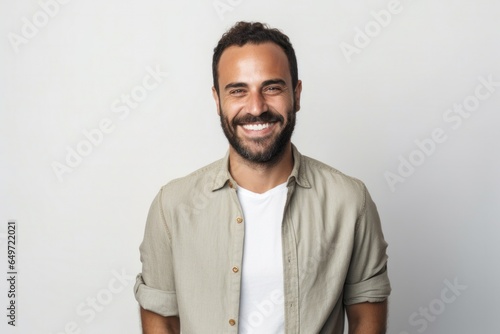 Portrait of a confident Israeli man in his 30s wearing a chic cardigan against a white background © Anne-Marie Albrecht