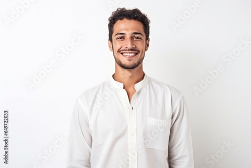 medium shot portrait of a confident Mexican man in his 20s wearing a simple tunic against a white background