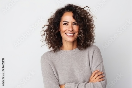 medium shot portrait of a confident Mexican woman in her 40s wearing a cozy sweater against a white background