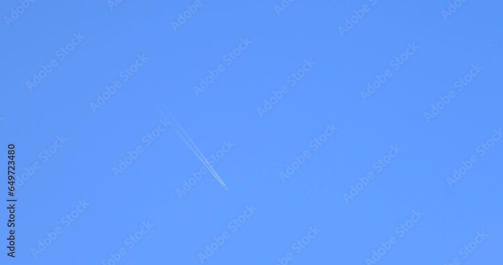 Airplane flying on deep blue sky with chemical direction trails Airplane flying on deep blue sky with chemical direction trails