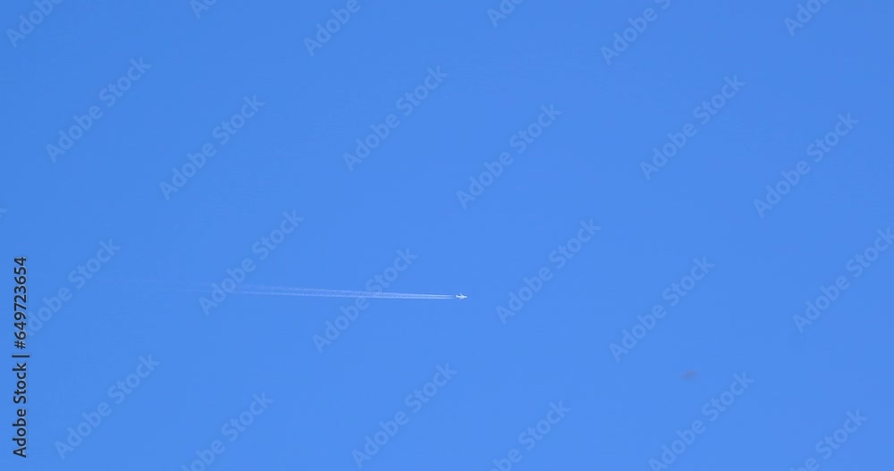 Airplane flying on deep blue sky with chemical direction trails Airplane flying on deep blue sky with chemical direction trails