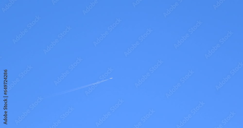 Airplane flying on deep blue sky with chemical direction trails Airplane flying on deep blue sky with chemical direction trails