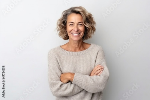 medium shot portrait of a happy Israeli woman in her 40s wearing a cozy sweater against a white background