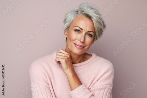 medium shot portrait of a Polish woman in her 50s wearing a cozy sweater against a pastel or soft colors background