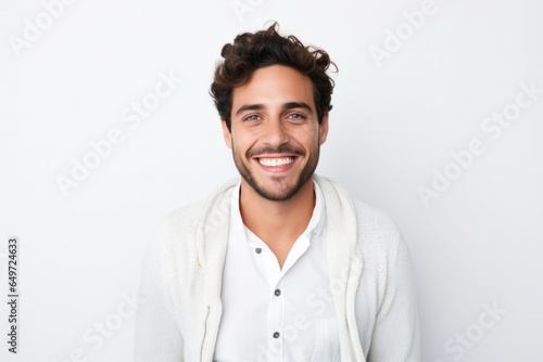 portrait of a happy Israeli man in his 20s wearing a chic cardigan against a white background